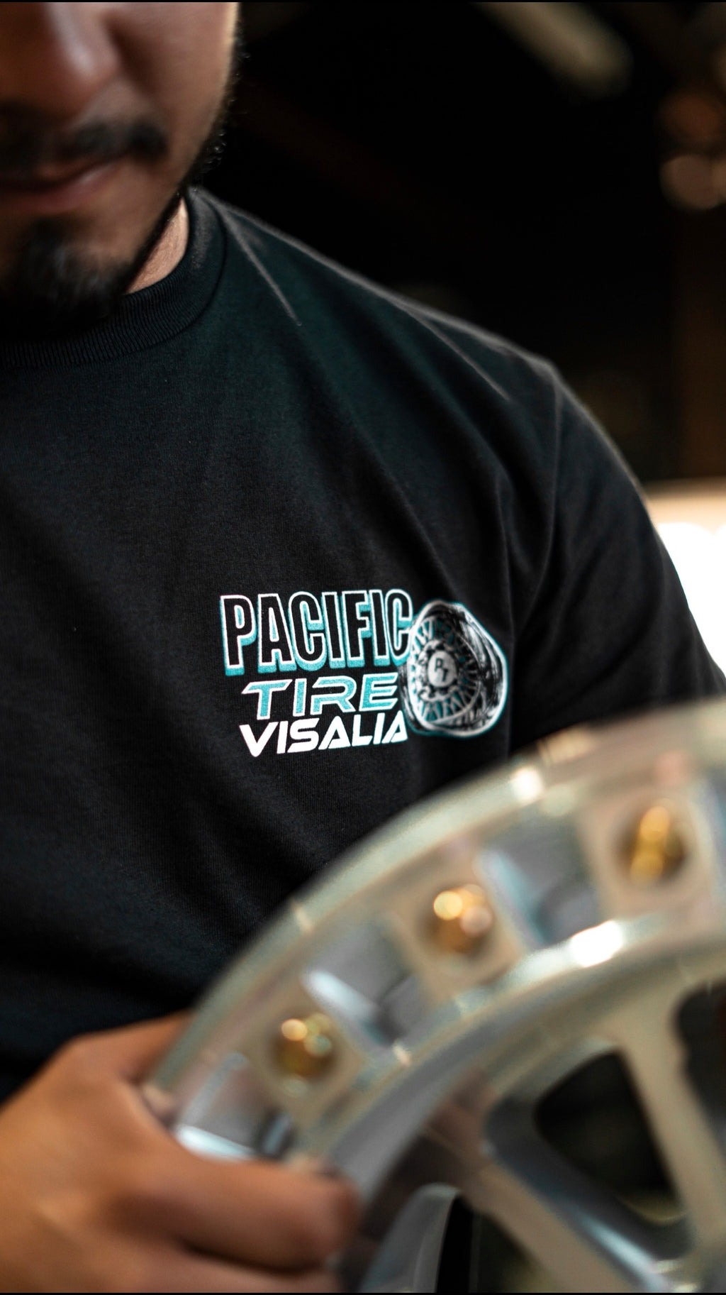 Front chest logo on the black Pacific Tire Visalia tee
