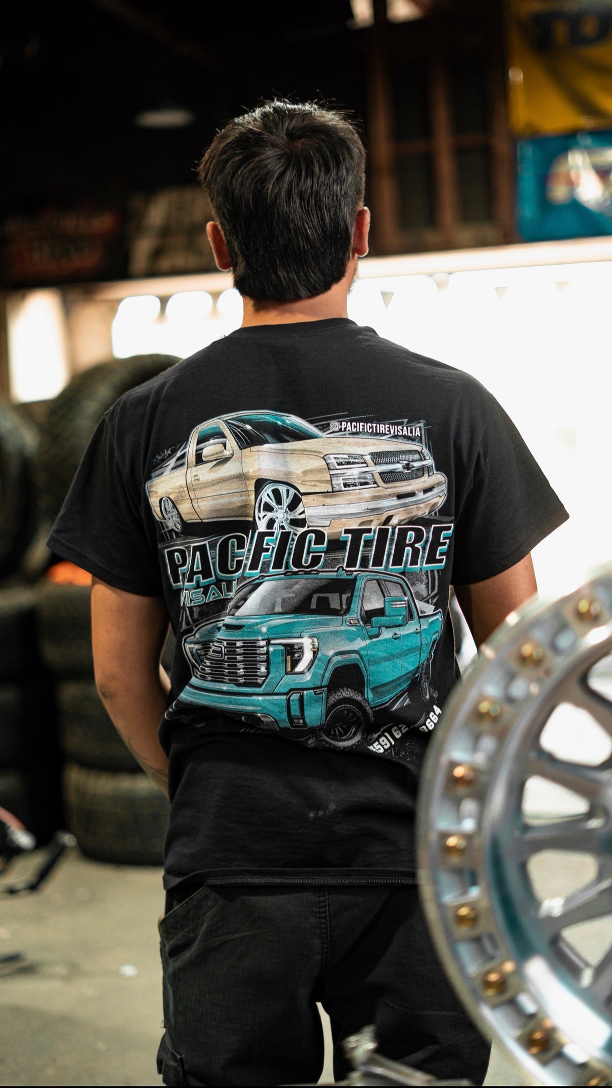 Back of the black Pacific Tire Visalia truck tee with full truck graphic